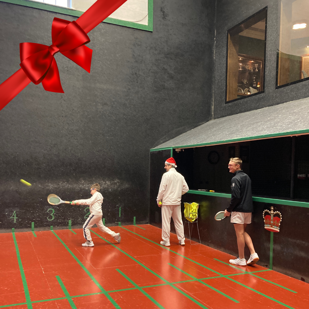 Queen's Ben Ronaldson giving a festive Junior Real Tennis lesson